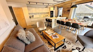 A modern living space with a sofa, coffee table, and dining area.