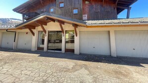 A wooden building with a sloped roof, a covered entrance, and a garage.