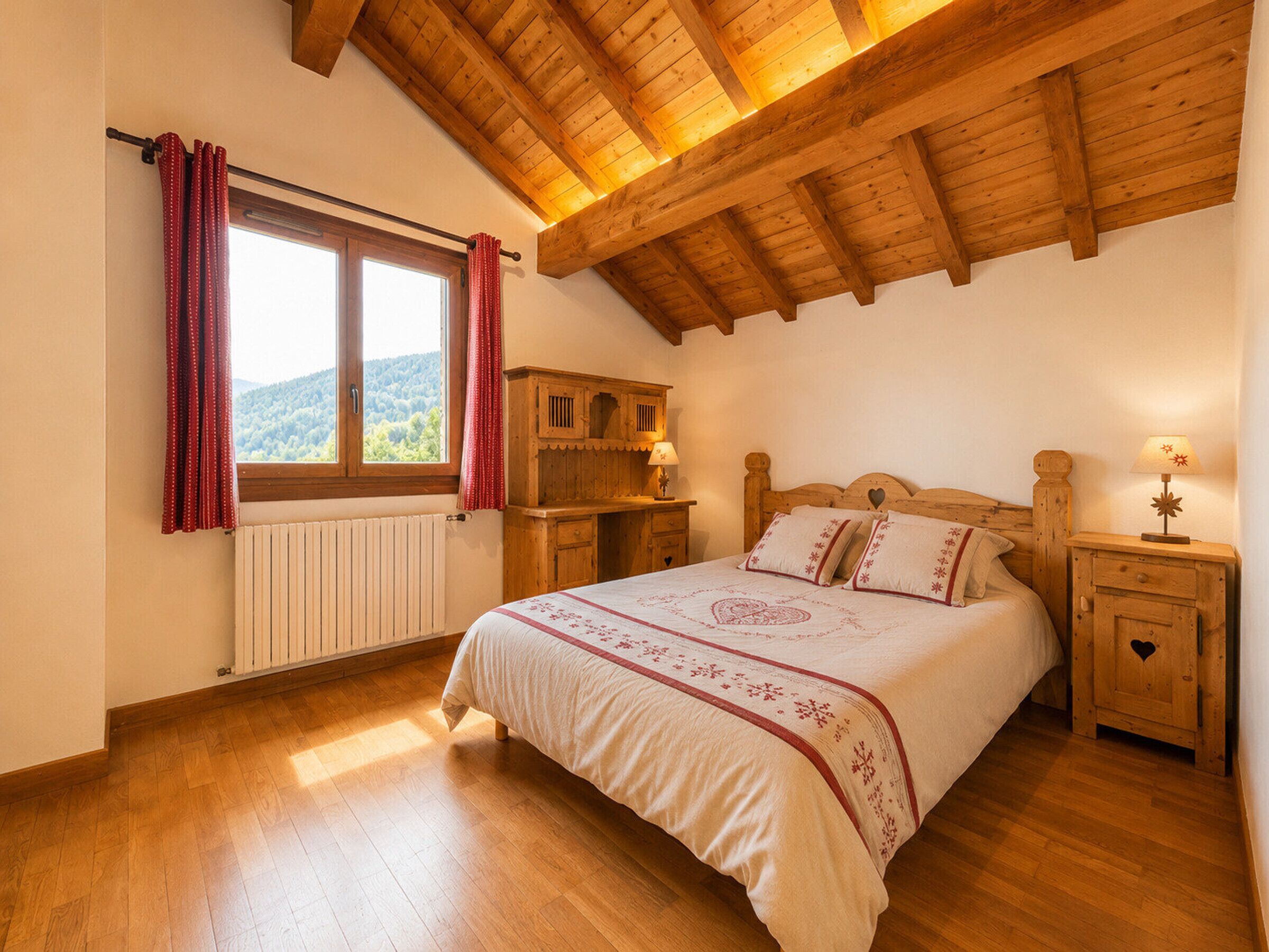Een slaapkamer met een houten plafond, een bed met een bloemenbedekking, een nachtkastje met een lamp, en een raam met gordijnen.