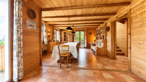 Un interior de madera con comedor, un banco y una escalera.