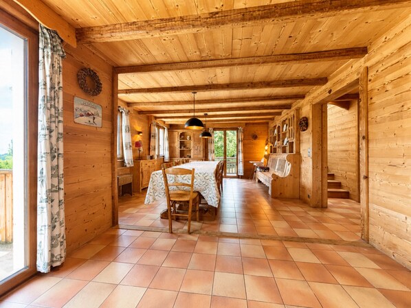 Un intérieur en bois comprenant un coin repas, un banc et un escalier.