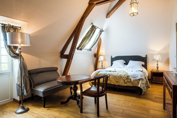 A bedroom with a bed, bedside tables, a chair, a table, and a floor lamp. - Aux Charmes de Maintenon - Adults Only (Maintenon)