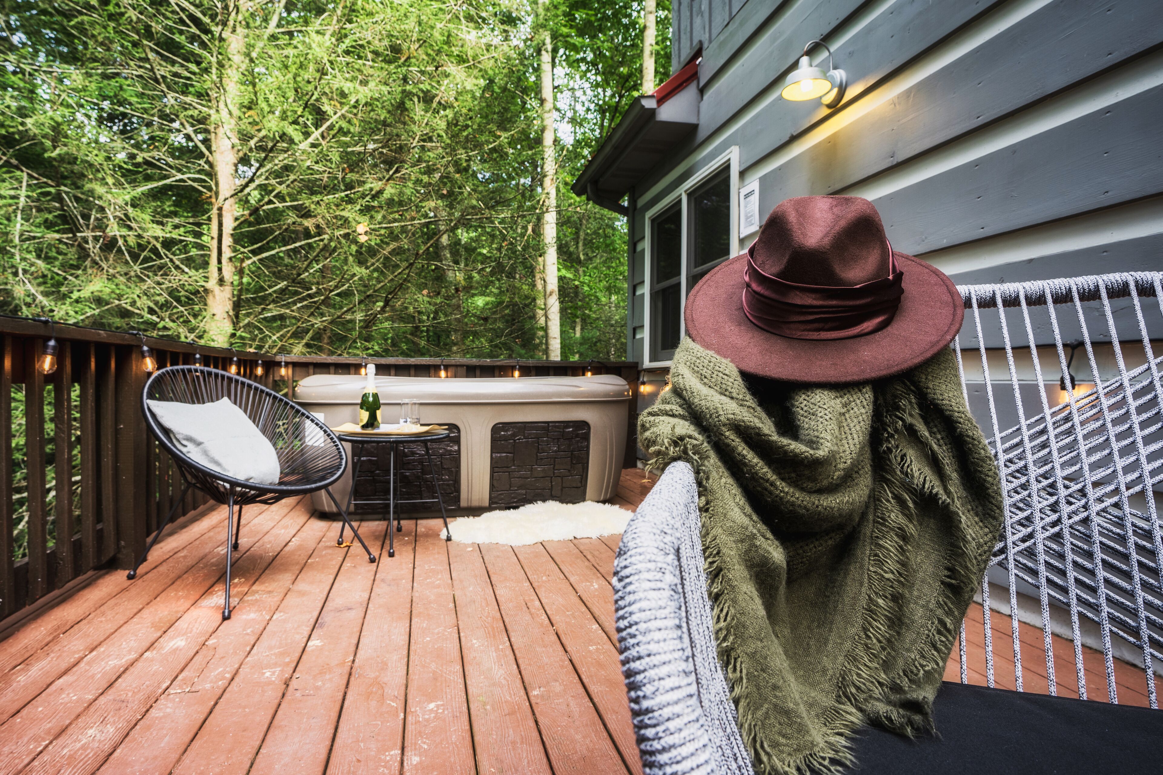 Una terraza de madera con una silla, una mesa pequeña y una chimenea.
