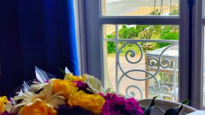 Ein Fenster mit Blick auf einen Strand und ein Balkon mit Metallgeländer.