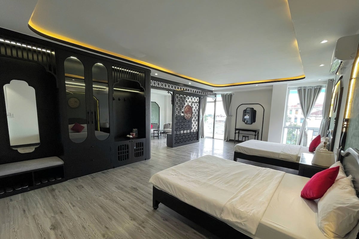 Une chambre d’hôtel moderne, dotée d’un grand lit, d’un bureau et d’un coin salon.