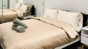 Una habitación de hotel con una cama grande, una mesita de noche, un espejo y un cuadro en la pared.