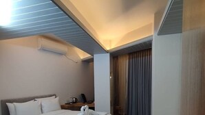 Ein modernes Hotelzimmer mit einem großen Bett, einem Schreibtisch und einem Kleiderschrank.