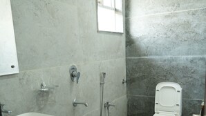 A bathroom with a white sink, a toilet, and a shower. - Hotel Royal Stay inn (Patancheruvu)