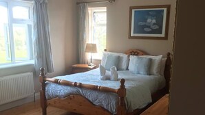 Ein Schlafzimmer mit einem hölzernen Bett, einem Nachttisch, einer Lampe und einem Gemälde an der Wand.