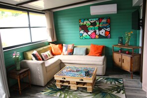A cozy living room with a sofa, a coffee table, and a painting on the wall.