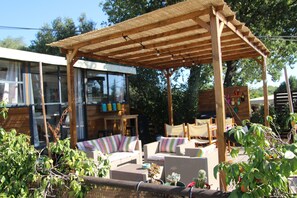 An outdoor seating area with wicker furniture and a pergola structure. - Beautiful mobile home with a furnished patio, 7 km from the beach   (Puget-sur-Argens)