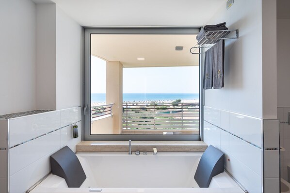 Ein modernes Badezimmer mit großem Fenster, einer Badewanne und einer Duschkabine.