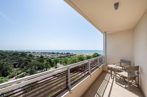 Ein Balkon mit Blick auf das Meer und einen entfernten Strand.