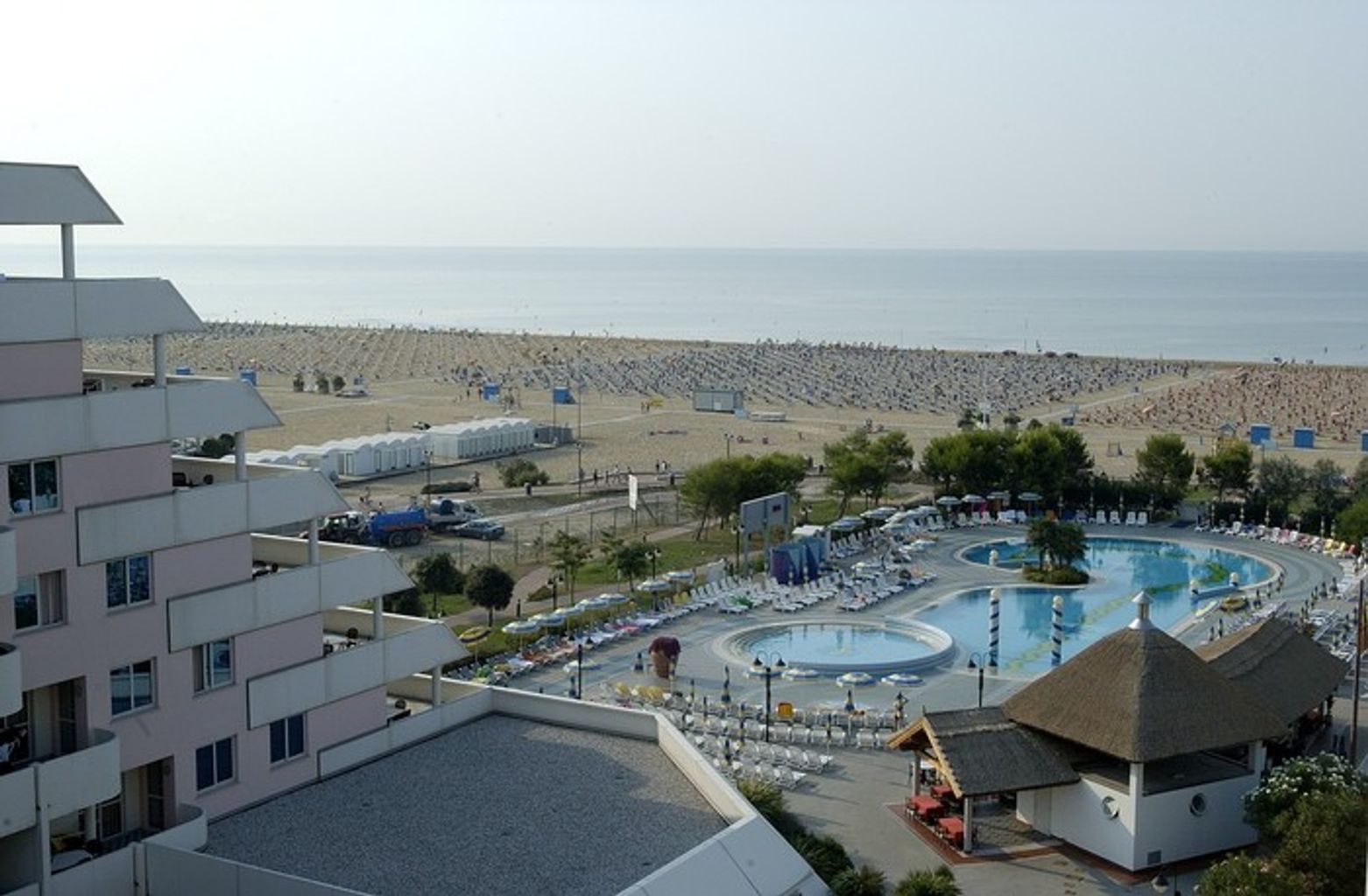 A resort with a large pool, beach, and multiple buildings.