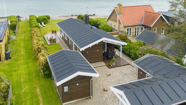 Un área residencial costera con casas de tejados inclinados y vistas al mar.