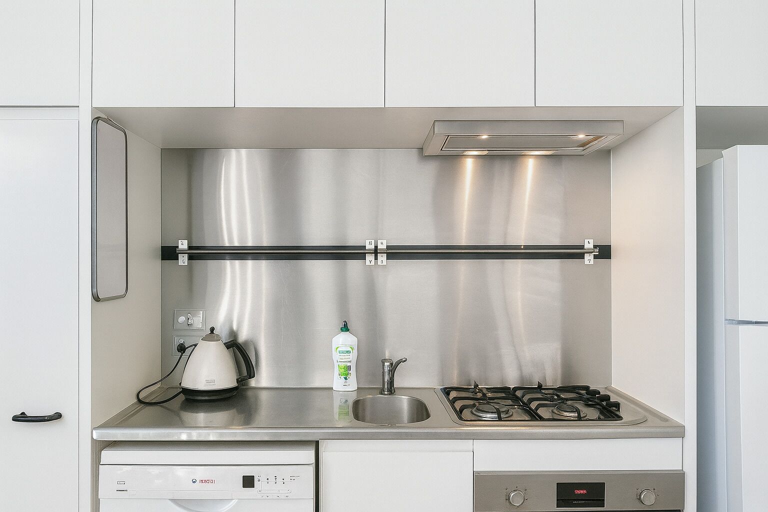 A modern kitchen with stainless steel appliances, a dishwasher, and a built-in oven.
