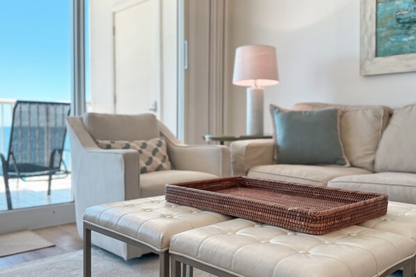 A modern living room with a white sofa, a cushioned bench, and a wicker tray.