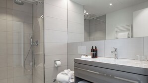 A modern bathroom with a shower, toilet, and vanity.
