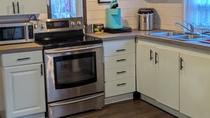 Una cocina equipada con microondas, horno, cafetera y lavaplatos.