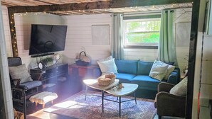 Una sala de estar acogedora con televisor, sofá y mesa de centro.