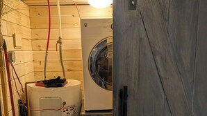 Un cuarto de lavado con lavadora, secadora y calentador de agua.