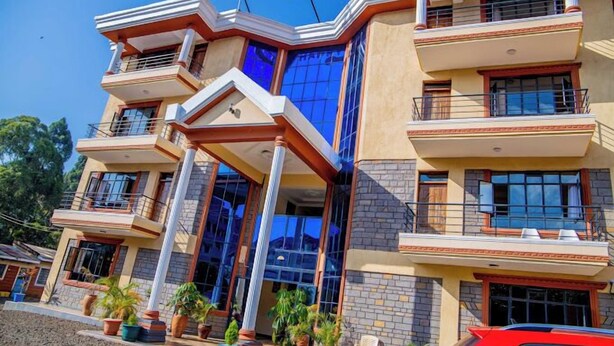 A multi-story hotel with a modern architectural design, featuring balconies, large windows, and a prominent sign reading "HAPPY STAY". - Happy Stay Resort Kisii (Kisii)