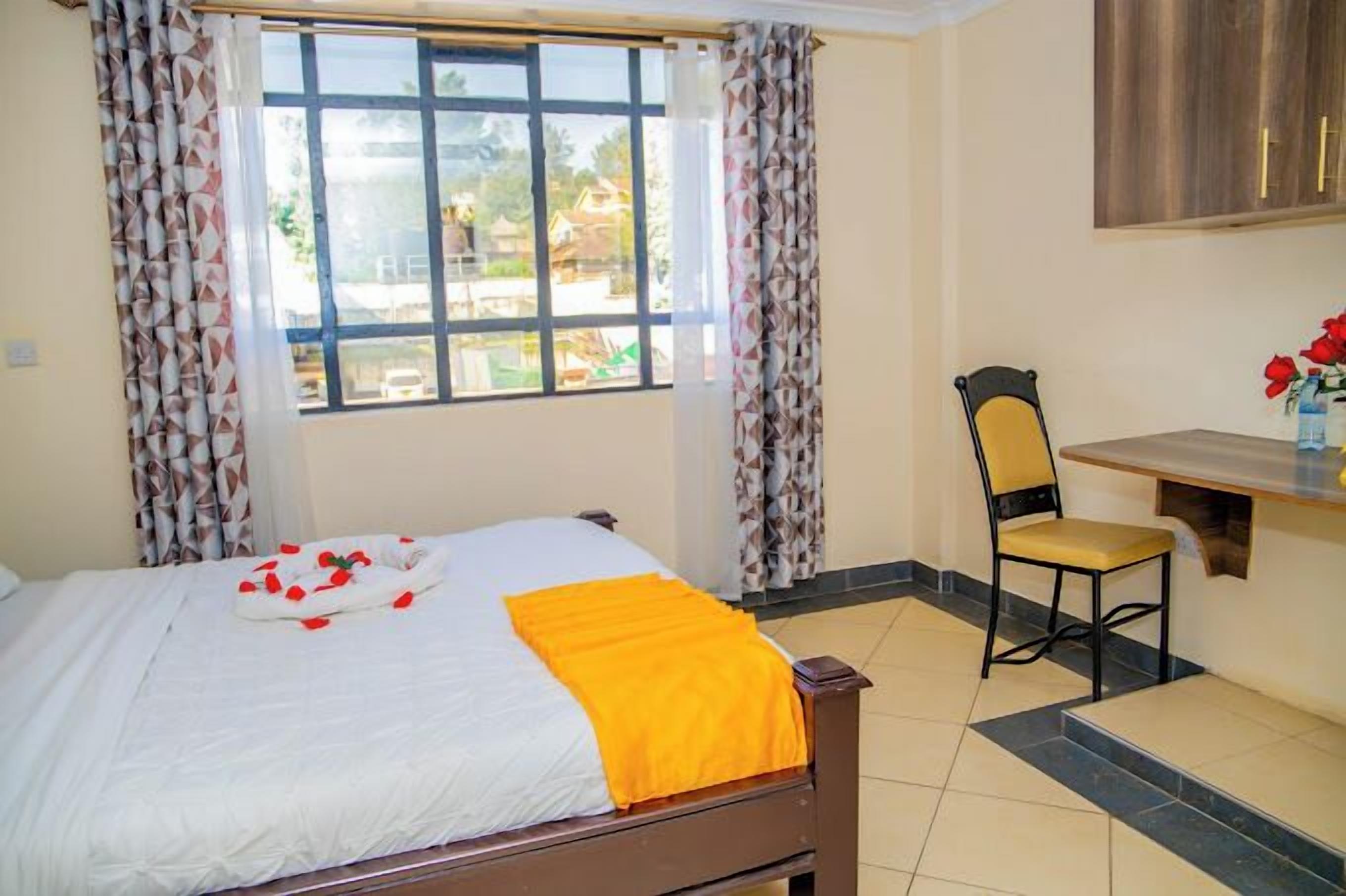 Una habitación de hotel con cama, escritorio y silla.