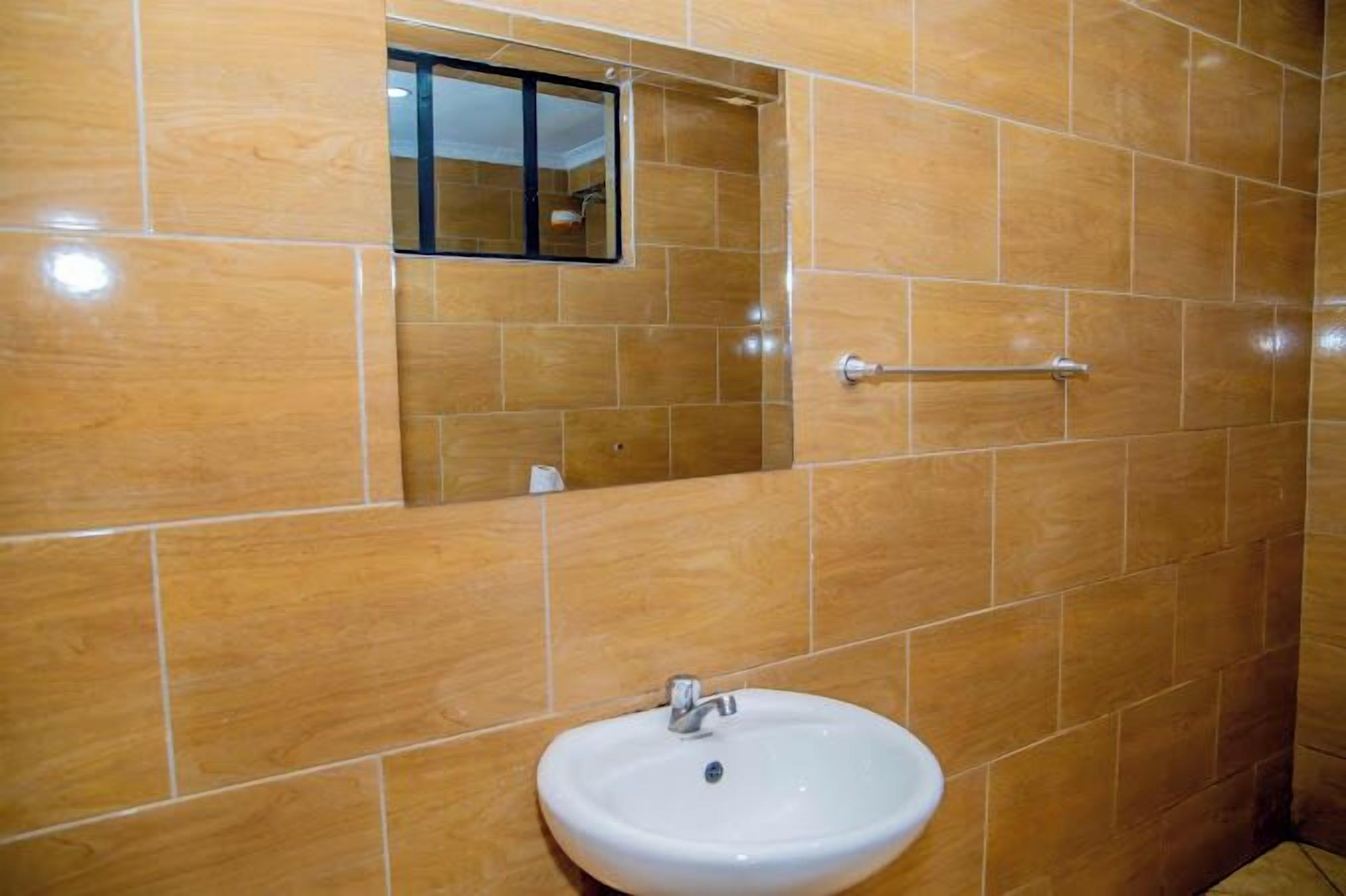 A bathroom with a white sink, a mirror, and a towel rack.