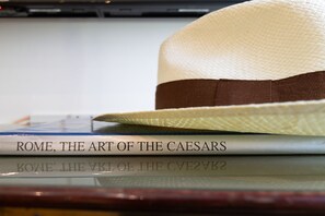 A book titled "ROME, THE ART OF THE CAESARS" and a straw hat on a table. - Crispi 30: A Stylish Apartment (Roma)