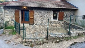 A stone house with a tiled roof, wooden shutters, and a fenced yard. - LE MAZET DE LA REGORDANE (Saint-André-Capcèze)