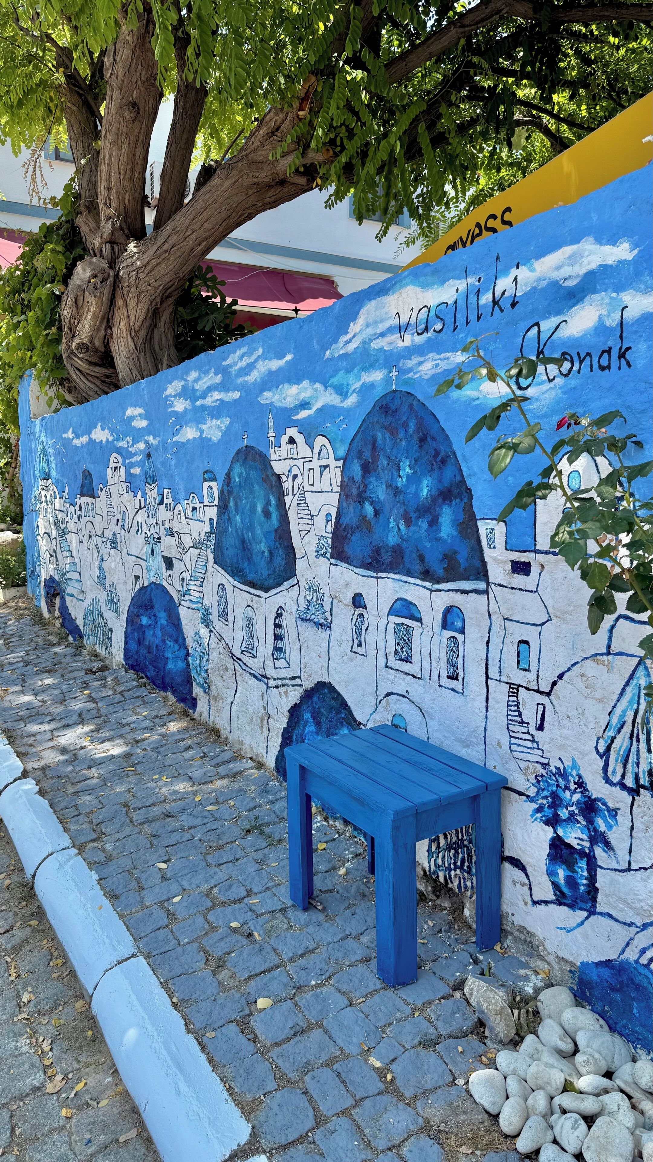Un mural con un banco, un árbol y un sendero adoquinado.