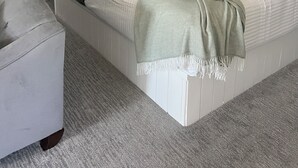 Une chambre à coucher avec un lit, une table de chevet et une fenêtre avec des rideaux.