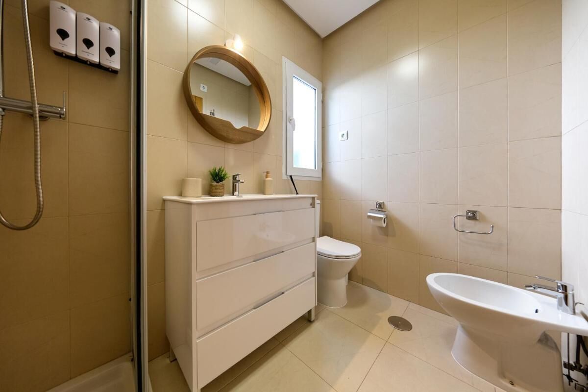 Un baño moderno con ducha, inodoro y lavamanos.