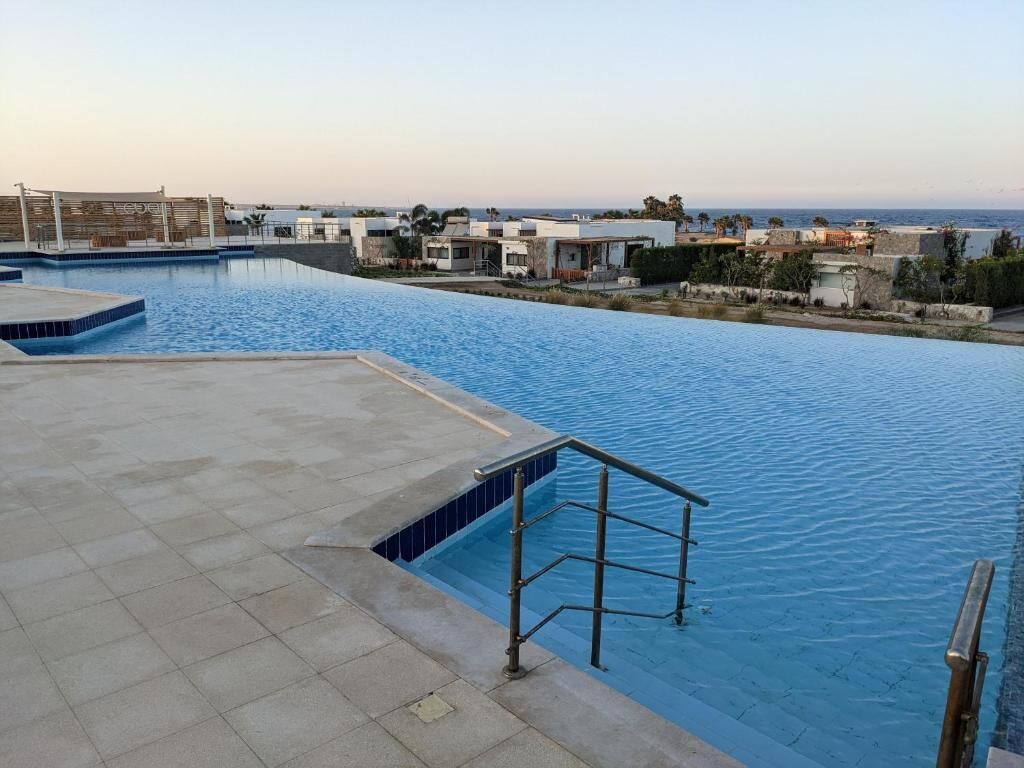 A swimming pool with a view of buildings and a clear sky.