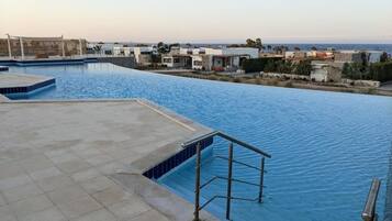 Una piscina con vistas a edificios y un cielo despejado.