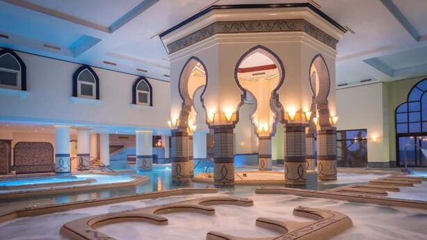 A luxurious indoor pool area with ornate arches and a central fountain. - Stayr Somabay - Bay life home rentals (Soma Bay)