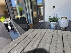 Ein Holztisch mit einem Blumentopf und einer Zierflasche.