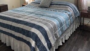 A bedroom with a bed, a ceiling fan, a nightstand, and a window with curtains. - Charming pet friendly 1-bedroom apartment with WiFi, AC in quaint Conneaut Lake (Conneaut Lake)