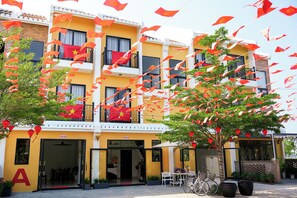 A hotel with multiple balconies, a large 'A' sign, and outdoor seating.