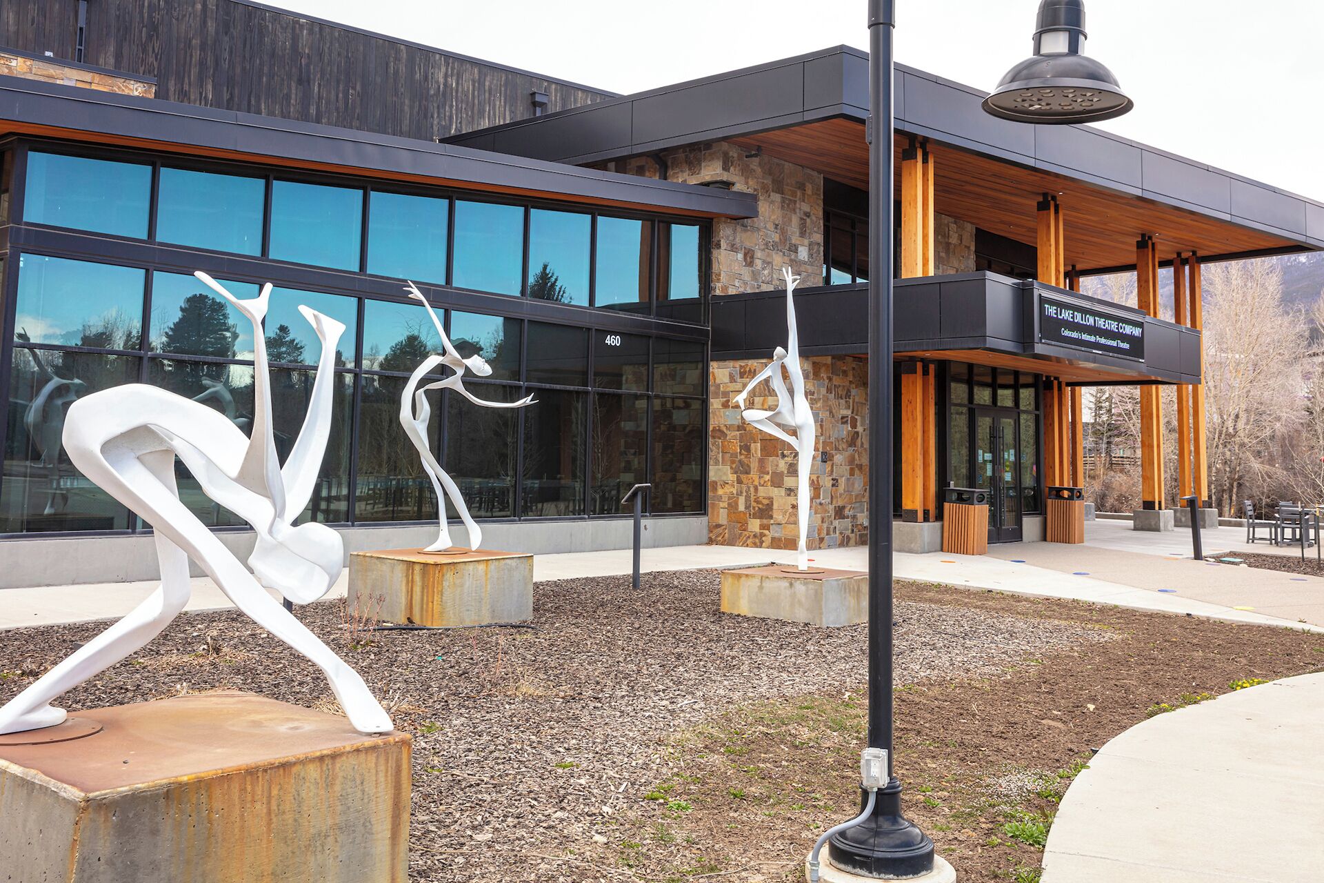 Ein modernes Gebäude mit großen Glasfenstern, einer Stein-Fassade und einem Schild für The Lake Dillon Theatre Company.
