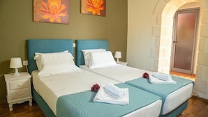 A double bed with teal bedding, white pillows, and a nightstand with a lamp. - Neriana Villa - Garden Paradise (Chania)