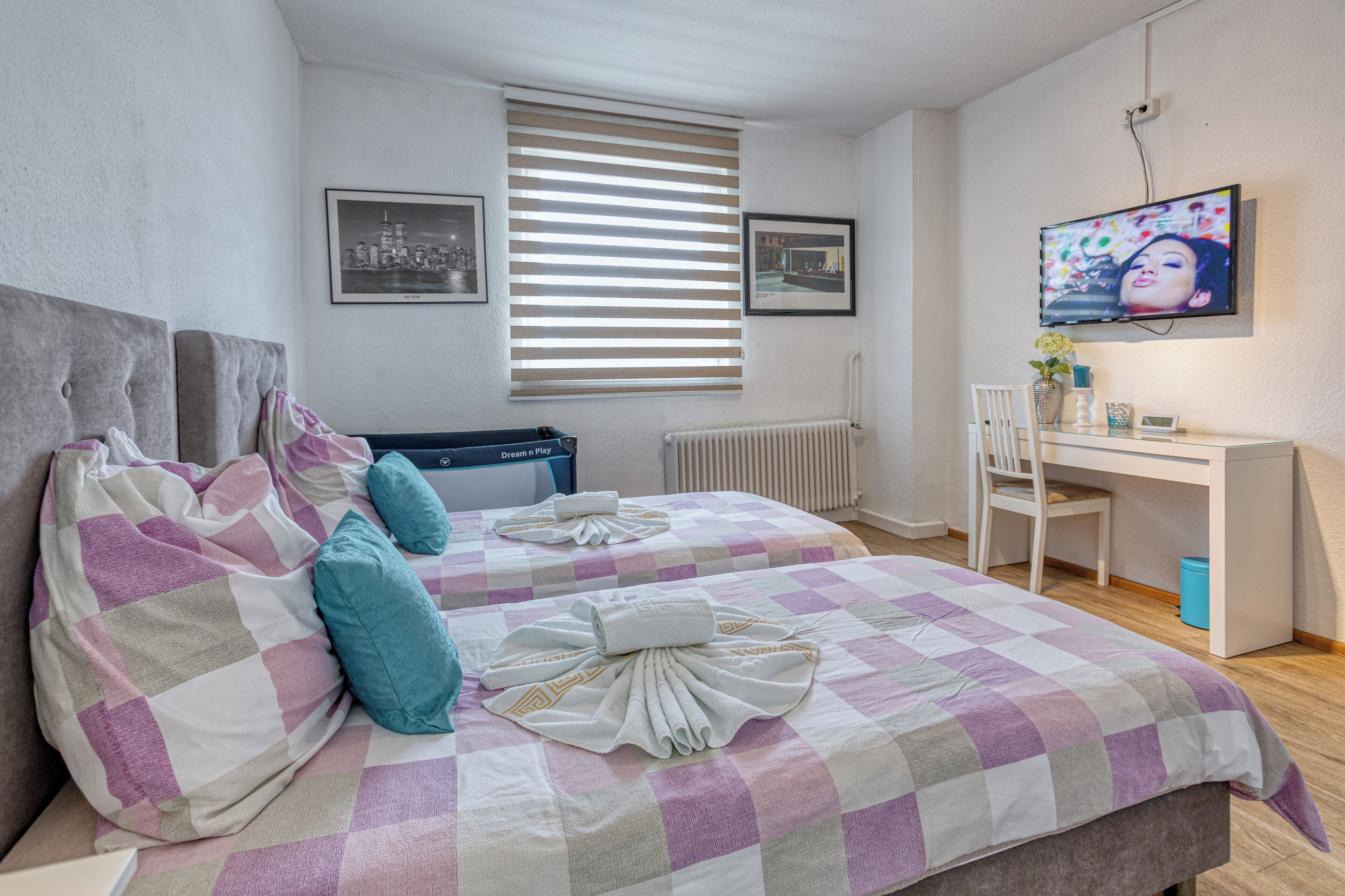 Une chambre avec deux lits, un bureau, une chaise et un téléviseur.