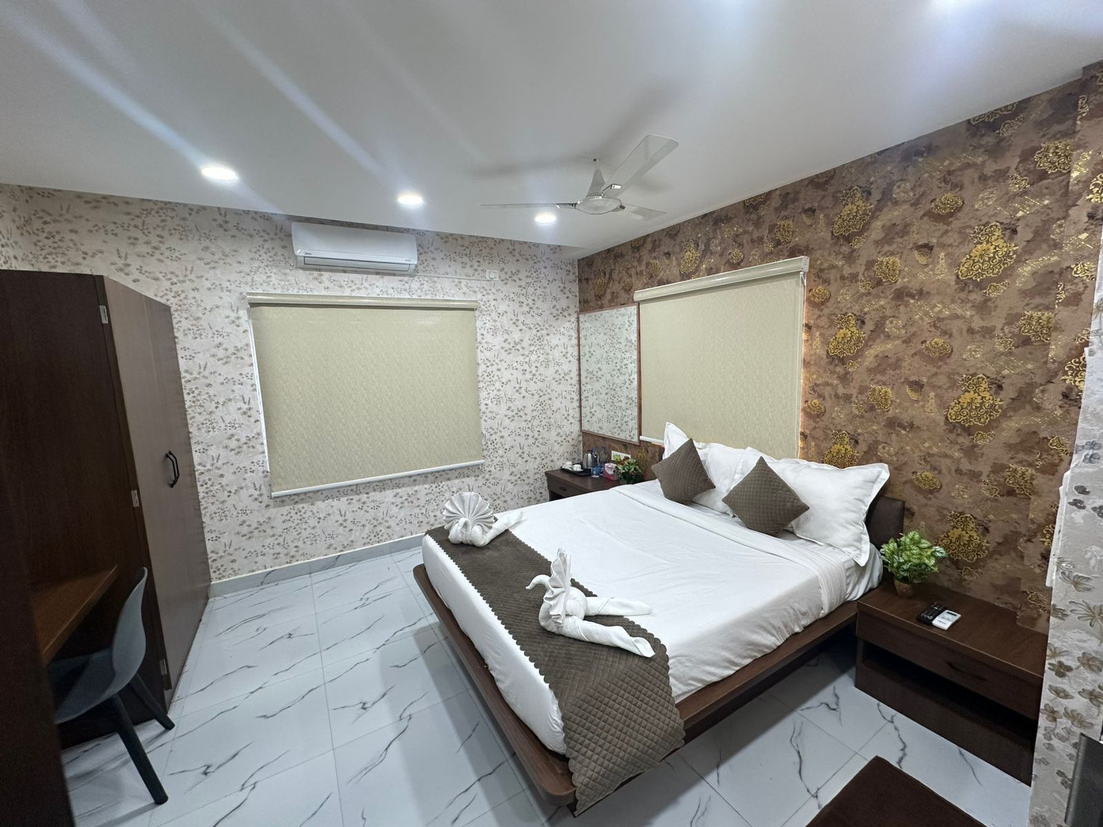 A bedroom with a bed, bedside tables, a desk, and a wardrobe.