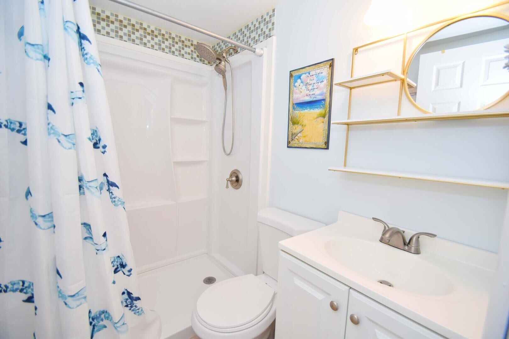 Un bagno con doccia, servizi igienici e lavandino.