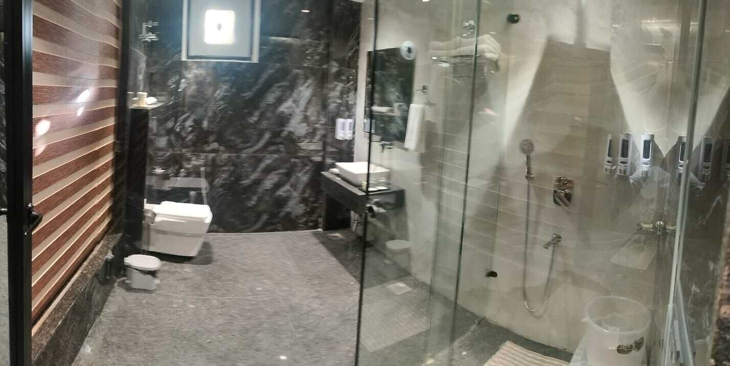 Ein modernes Badezimmer mit Marmorboden, Toilette, Waschbecken und einer Duschkabine.