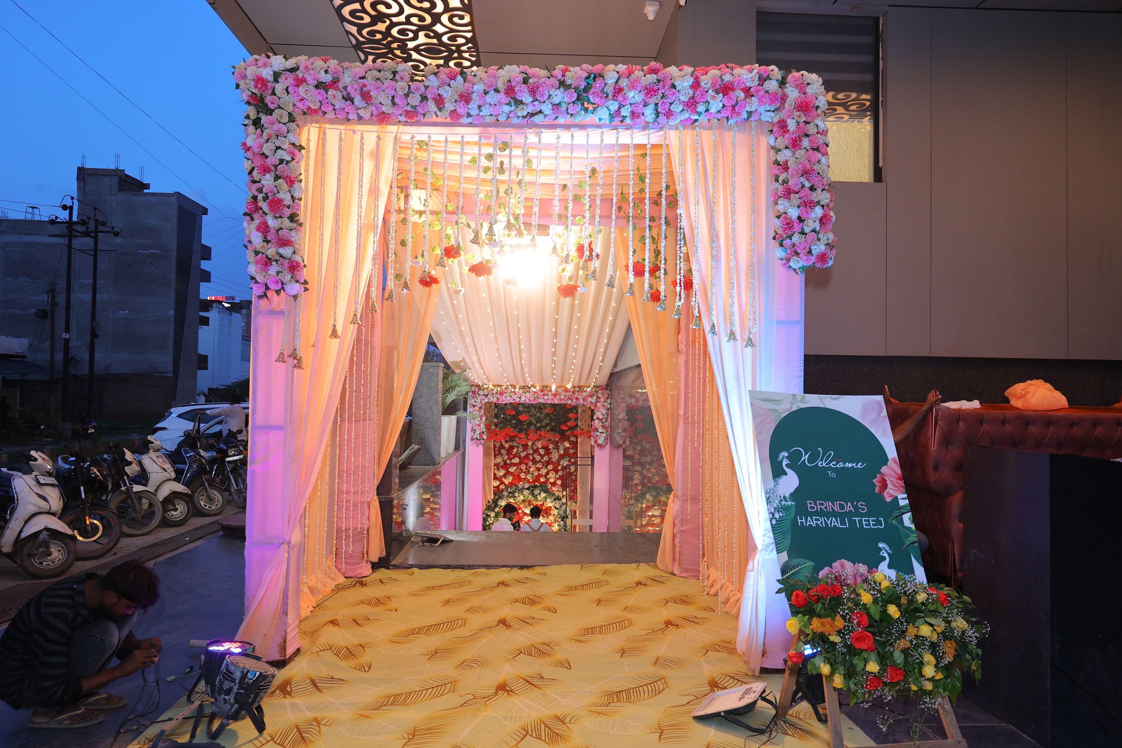 An indoor setting with a floral archway, a welcome sign, and a patterned carpet.