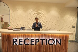 A reception desk with a wooden finish and the word "RECEPTION" prominently displayed. - SNJ TAJ GRAND HOTEL (Agra)