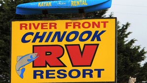 A sign for River Front Chinook RV Resort with a kayak rental and Mini Mart propane sign.