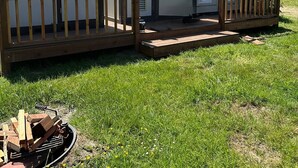 Portable portable toilets with a wooden deck in a grassy area.