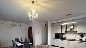 A modern living room with a sofa, dining area, and kitchen. - The Window on Assisi (Bastia Umbra)